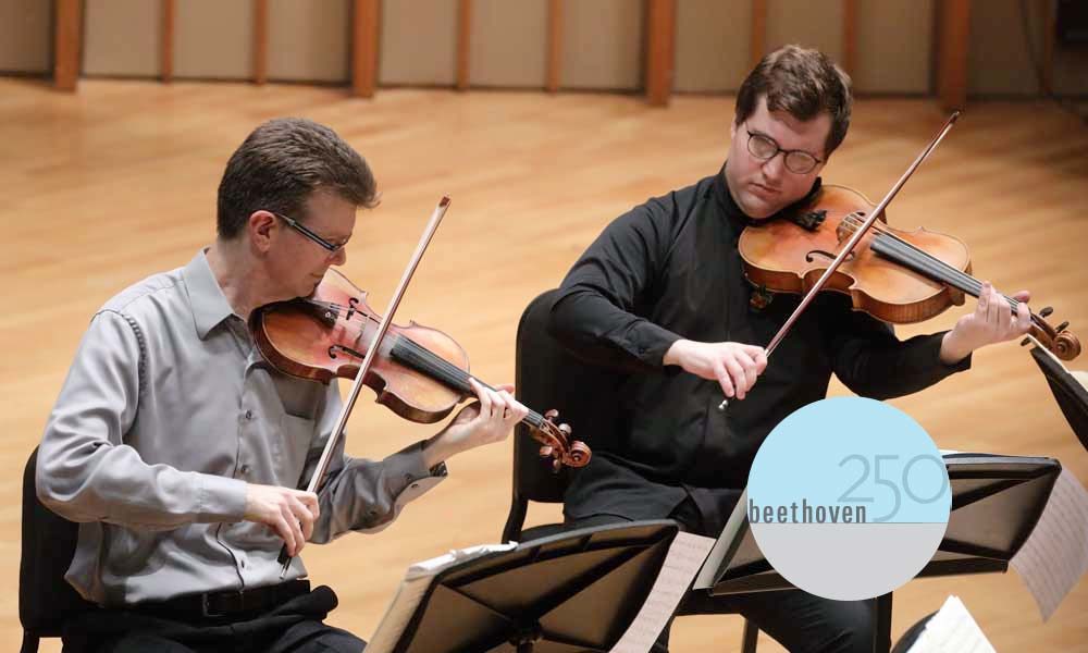 Two faculty members playing violin and viola, respectively.