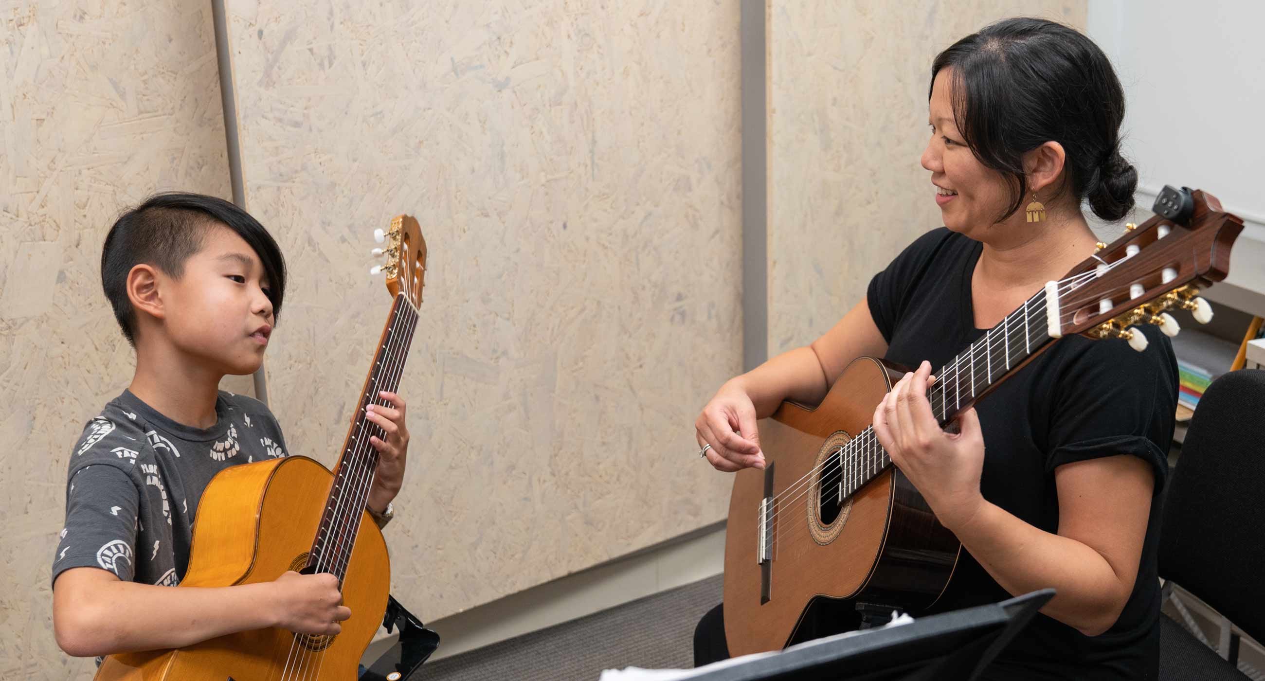 A classical guitar teacher with her young student.