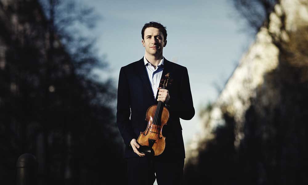 Noah Bendix-Balgley holding a violin.
