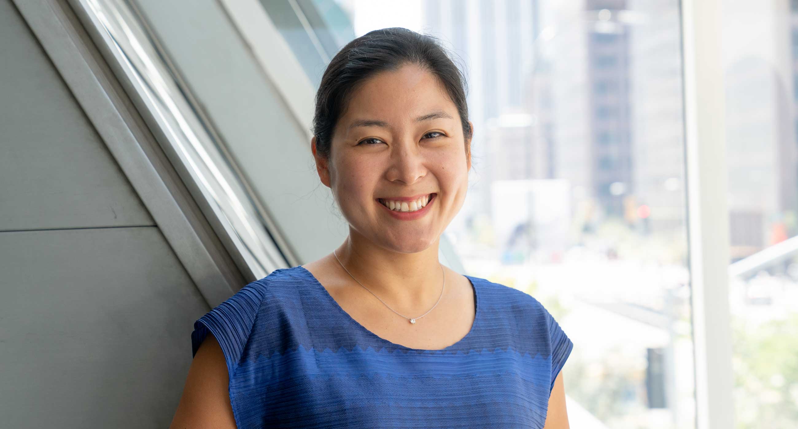Clara Yang smiling in front of a window.