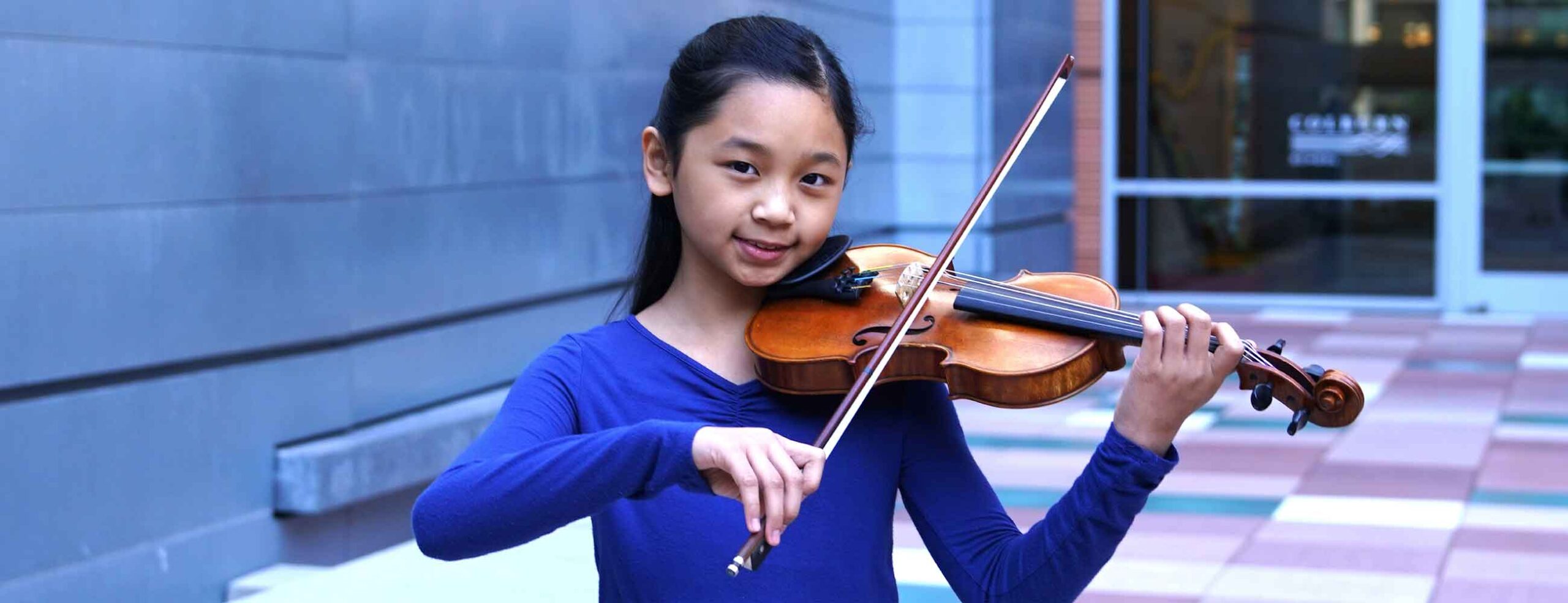 Young violinist standing on plaza