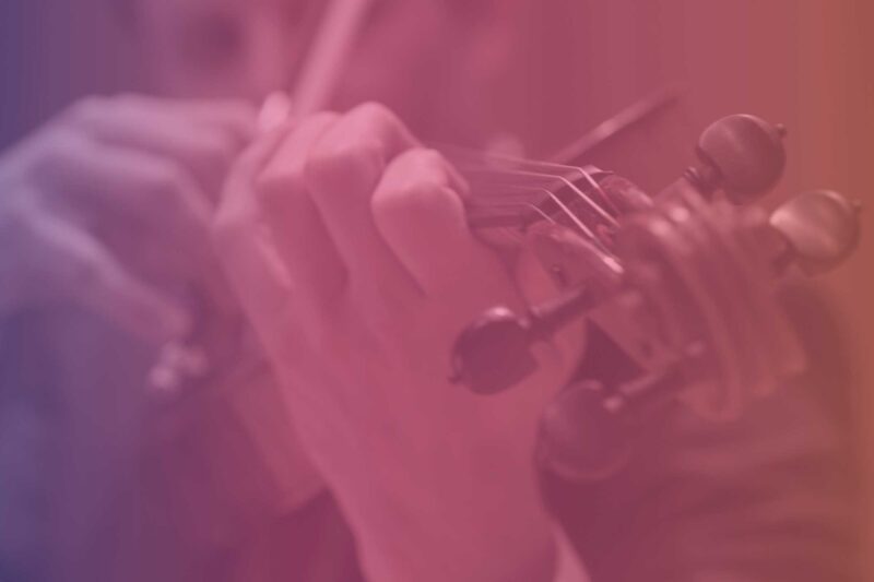 Purple, pink, and orange gradient colored photo of violist playing